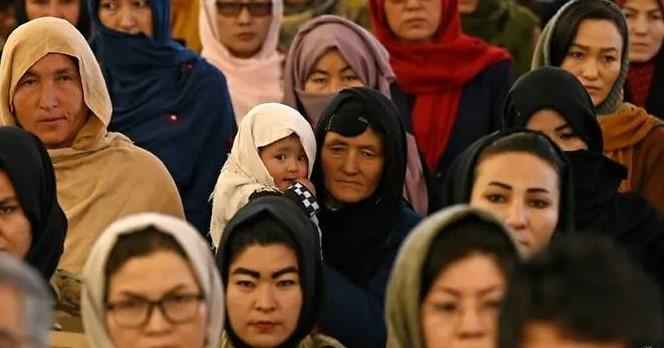 A Hazara mother holds her child in a crowd celebrating International Women's Day in Bamiyan Province, Afghanistan - Avaz