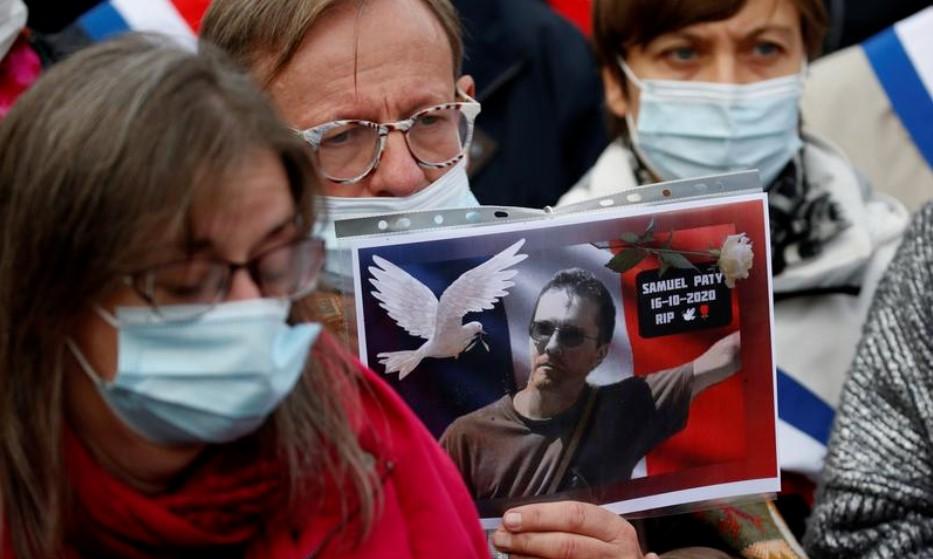 A person holds a picture of Samuel Paty, the French teacher who was beheaded on the streets of the Paris suburb of Conflans St Honorine, during a tribute at the Place de la Republique, in Lille, France - Avaz