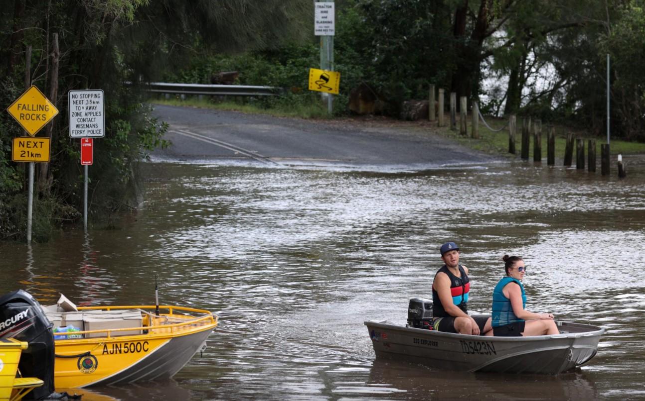 People in a boat navigate floodwaters resulting from prolonged rains northwest of Sydney in Wisemans Ferry, Australia, March 25, 2021. - Avaz