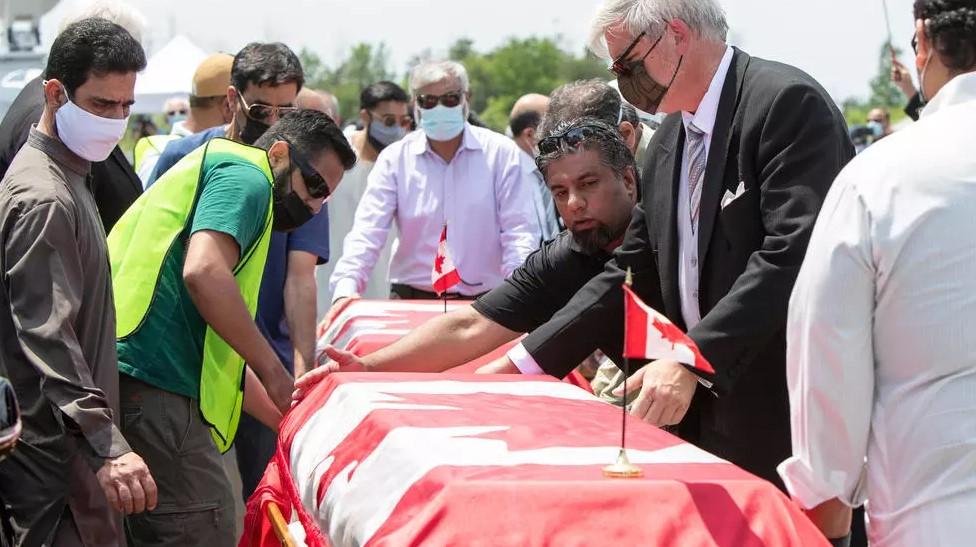 Pallbearers move the caskets of four members of the Afzaal family at the Islamic Centre of Southwest Ontario on June 12, 2021 - Avaz