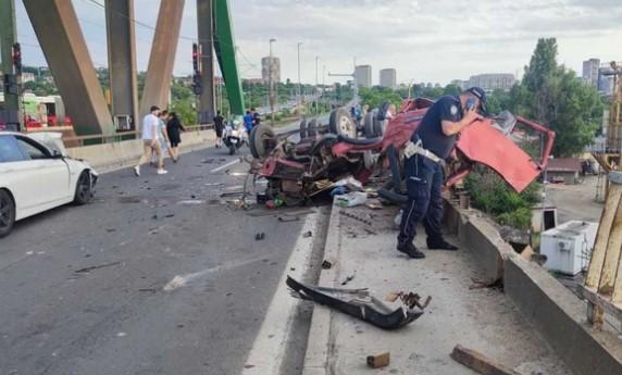 Smrskani dijelovi kamiona i BMW-a rasuti po putu, dio vozila visi preko ograde mosta