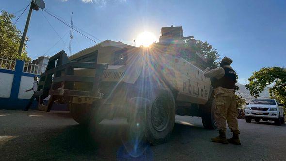 A national policeman talks with his colleagues next to an armored police car in Port-au-Prince, Haiti - Avaz