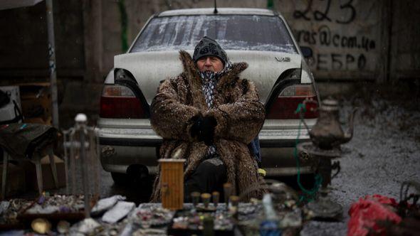 A vendor sits at a flea market in Kyiv, Ukraine, Saturday, Feb. 4, 2023 - Avaz