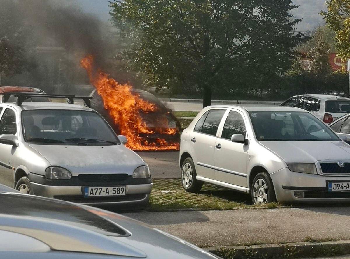 Gori automobil na parkingu, vatrogasci na licu mjesta